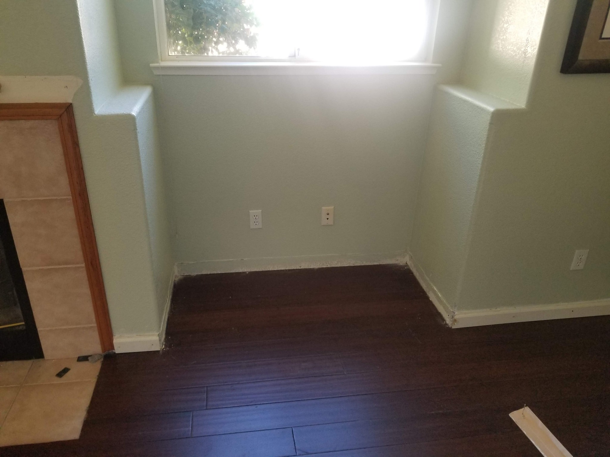 Empty wall niche beside a fireplace before cabinet installation.