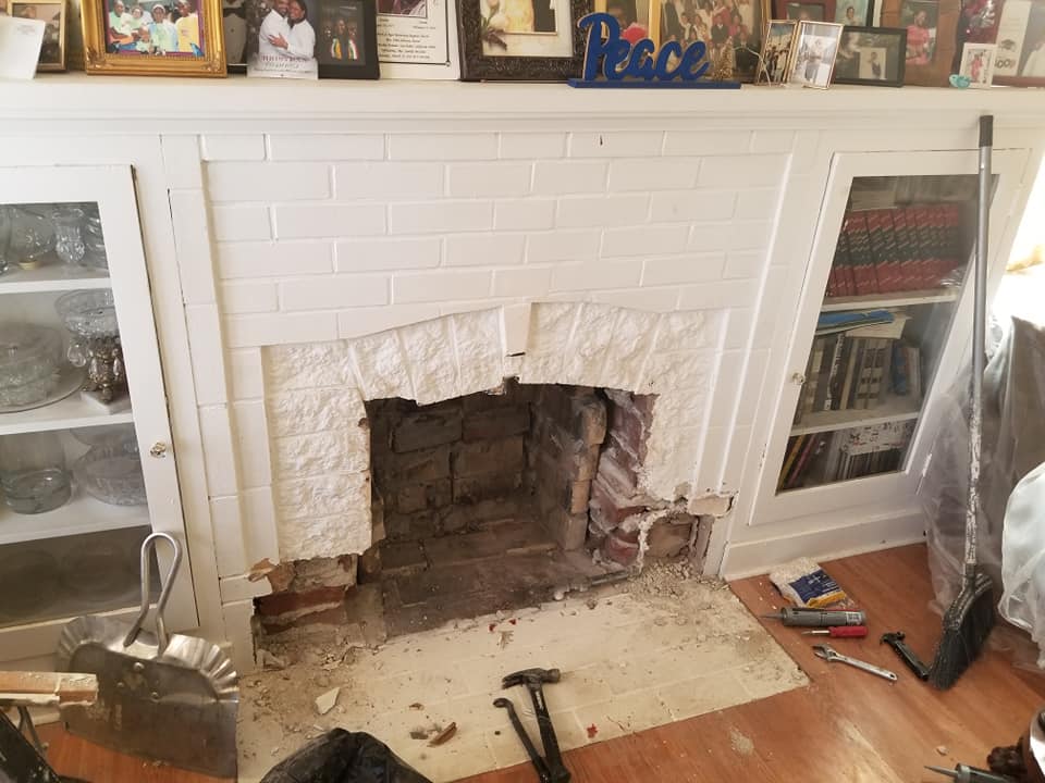 Fireplace opening and damaged surround before renovation.