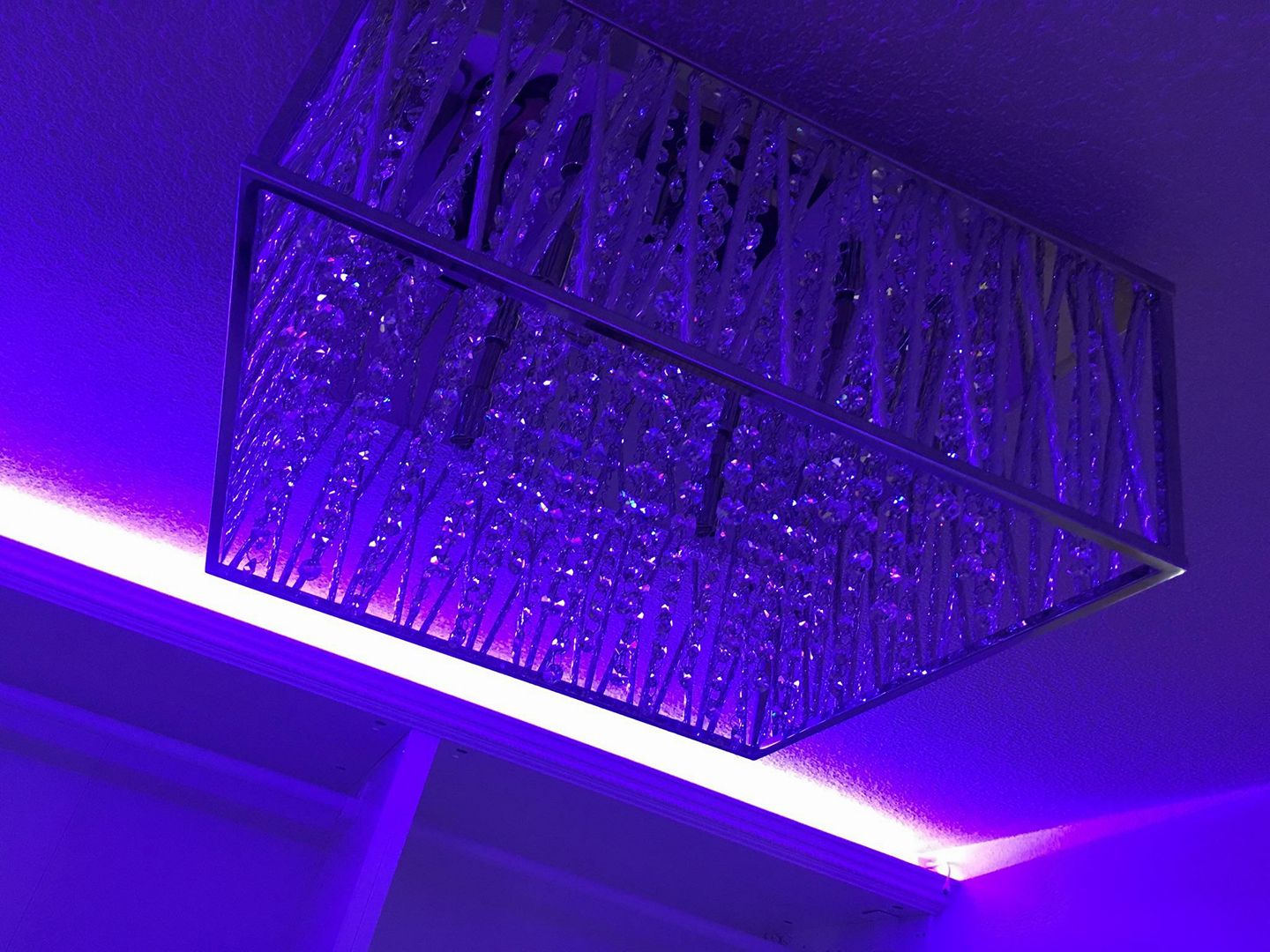 Ceiling chandelier detail with purple accent lighting.